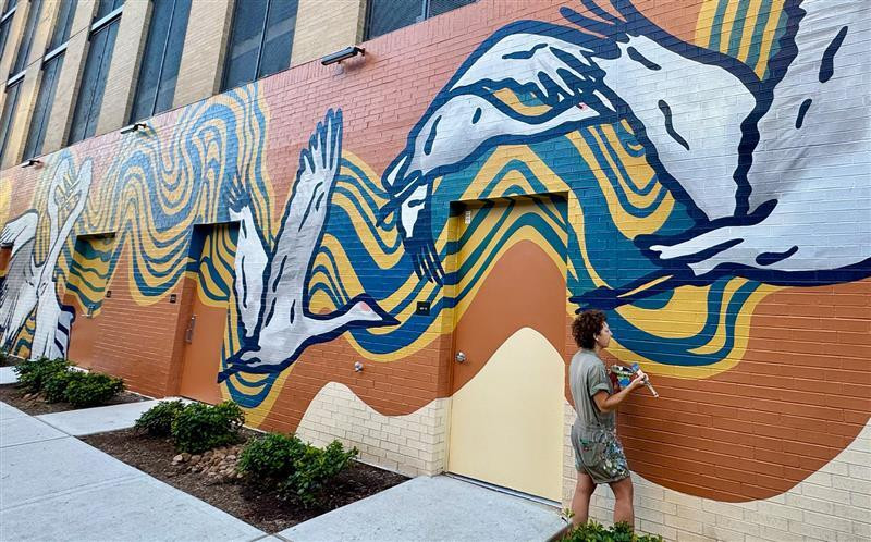 Mural of birds and abstract water painted on the back of 1010 Waugh Apartment building.
