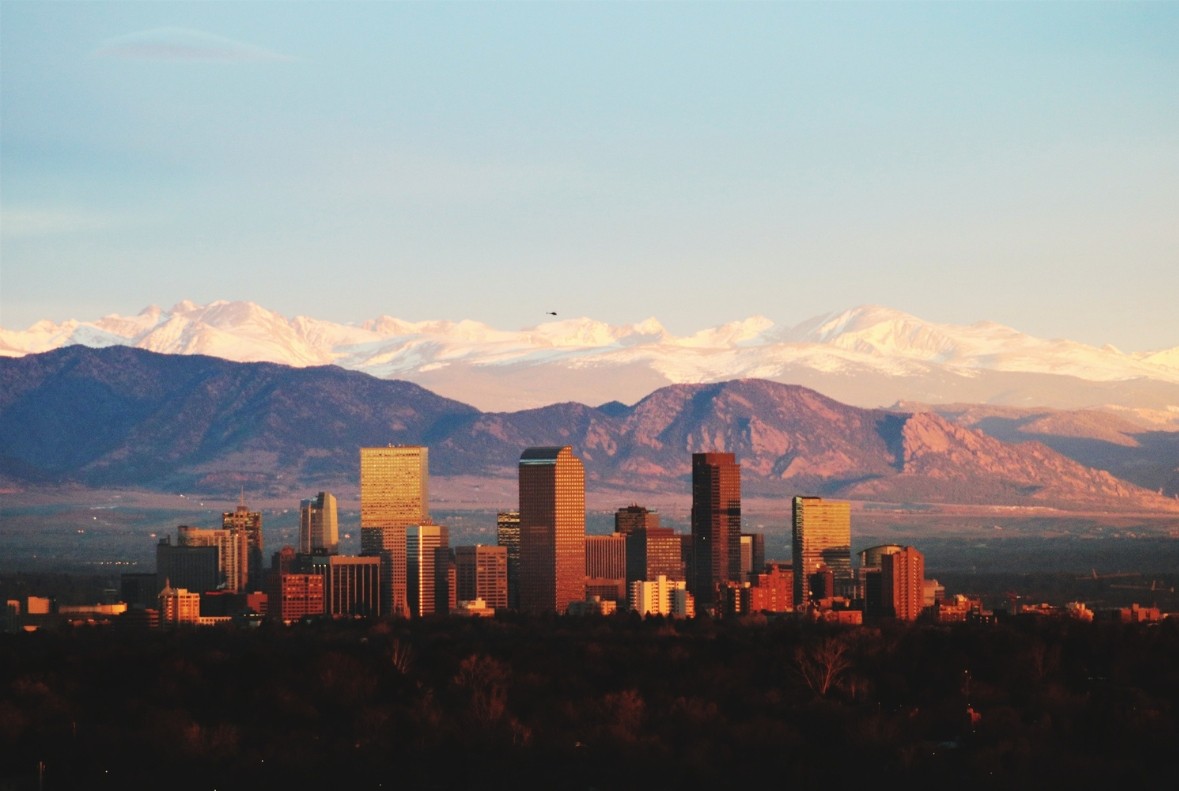 Denver skyline with the Rocky Mountains in the background.