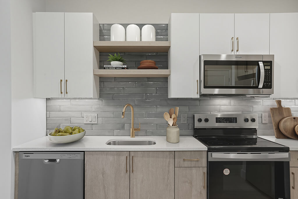 Sand design package kitchen with light cabinets and light gray tile backsplash