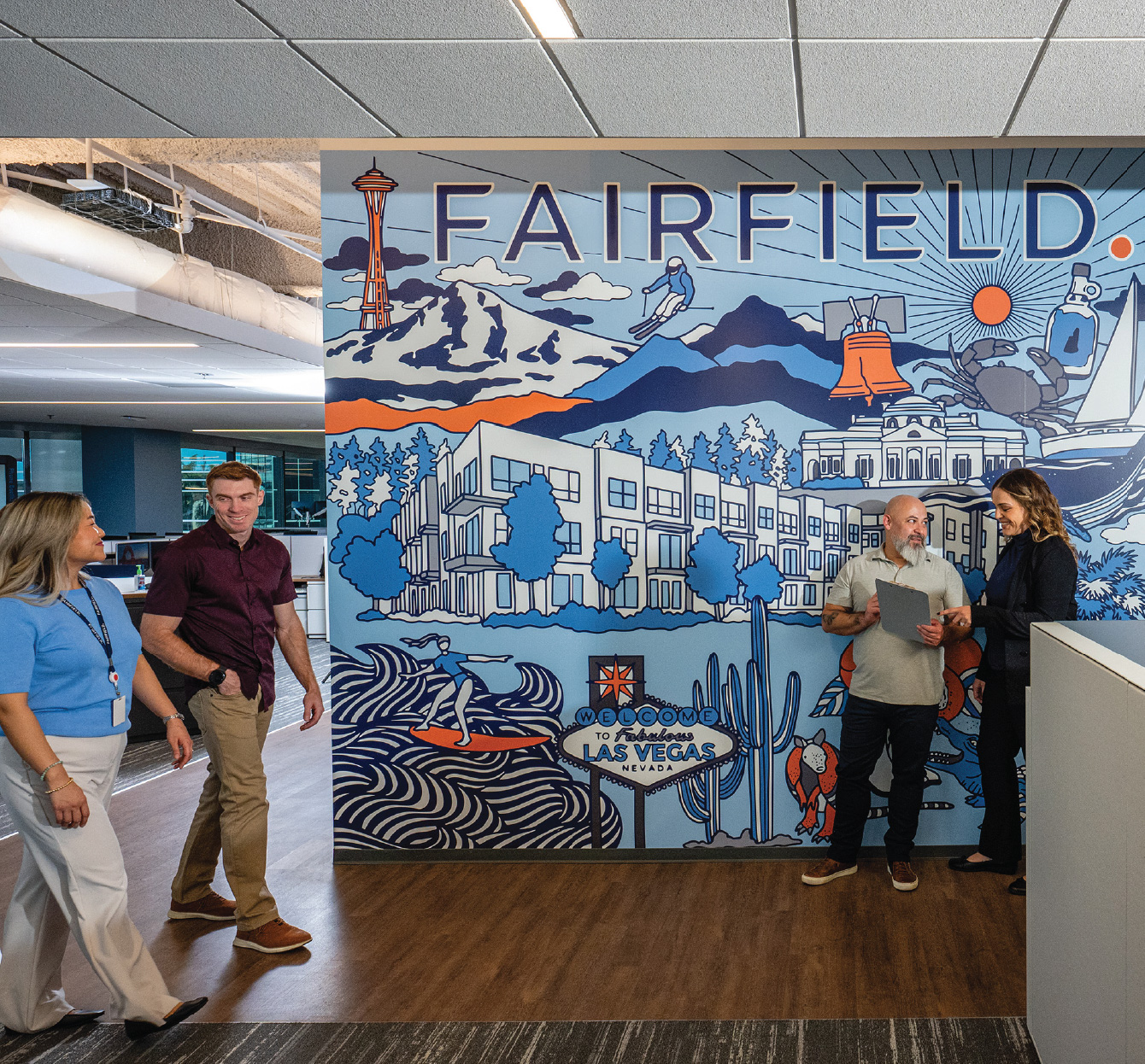 Action shot of associates walking in front of a Fairfield mural in the office.